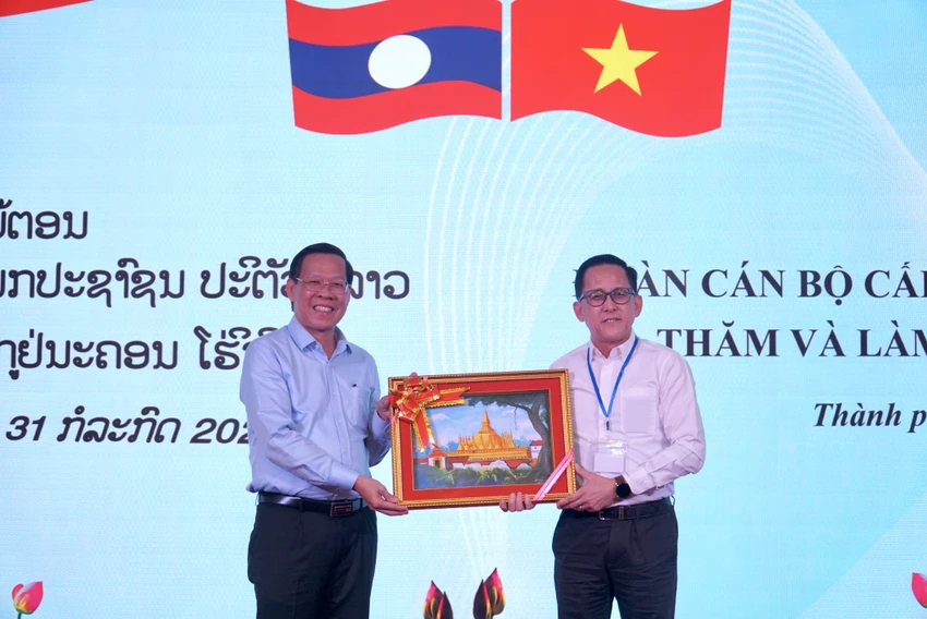 Ông Santisouk Simmalavong trao quà lưu niệm cho Chủ tịch UBND Phan Văn Mãi. Ảnh: BẢO PHƯƠNG doan-can-bo-cap-cao-cua-dang-nhan-dan-cach-mang-lao-5.JPG