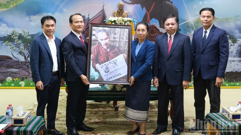 Phó Bí thư Thường trực Thành ủy Đà Nẵng Nguyễn Đình Vĩnh và đồng chí Phan Thái Sơn, quyền Trưởng đại diện Báo Nhân Dân tại miền trung-Tây Nguyên trao tặng bức ảnh Bác Hồ đọc Báo Nhân Dân cho lãnh đạo tỉnh Attapue-Lào. (Ảnh: ANH ĐÀO)